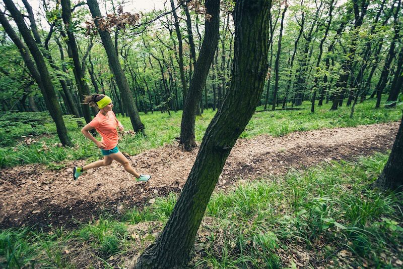 Vrouw loopt op bospad - trailrunning